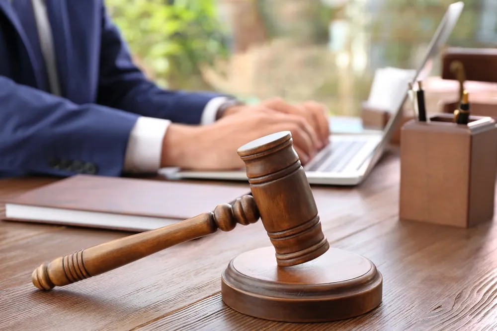 Lawyer working at a laptop with a gavel on the desk