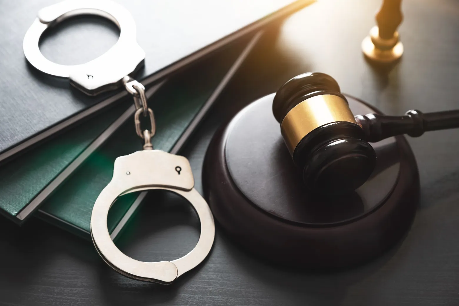 Handcuffs and a judge's gavel on a desk