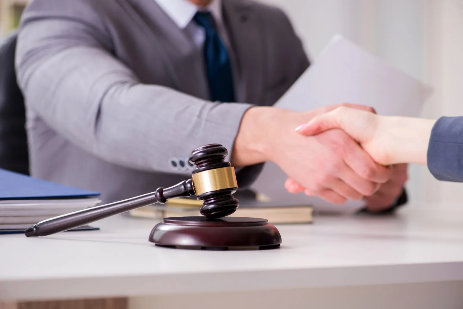Handshake across a desk with a judge's gavel